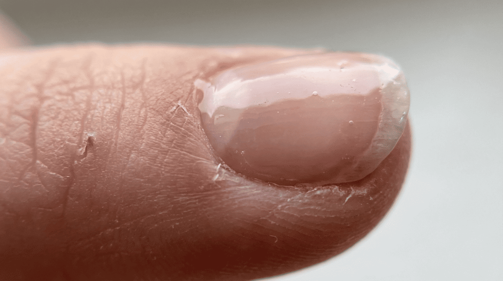 Top coat tocando la cutícula en uña en gel provocando levantamiento desde la base